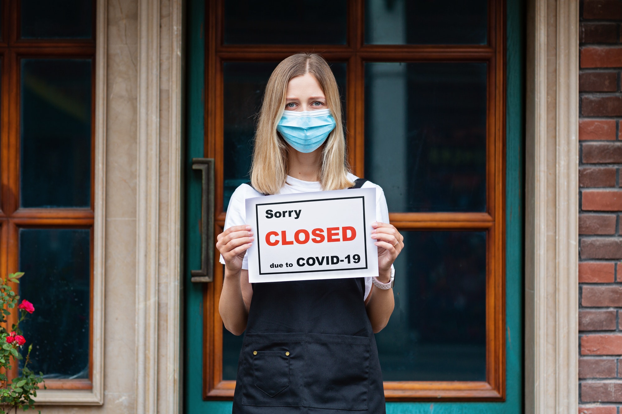 Restaurant owner holding note sorry closed due to covid19. Shutdown coronavirus quarantine